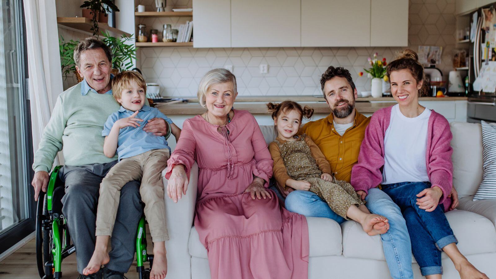 multi-generational family sitting on a couch; grandparents, parents, and children